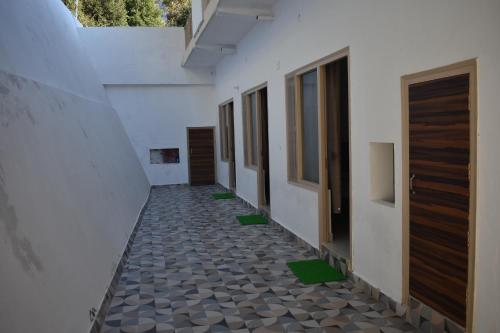 a corridor of a building with a floor with green tiles at Chopta House Hotel and Restaurant in Sari