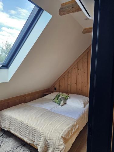 a bed in a room with a large window at Domek LUNA in Olchowiec