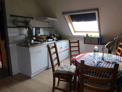 a kitchen with a table and chairs and a kitchen with a window at Emon nos-ôtes in Namur