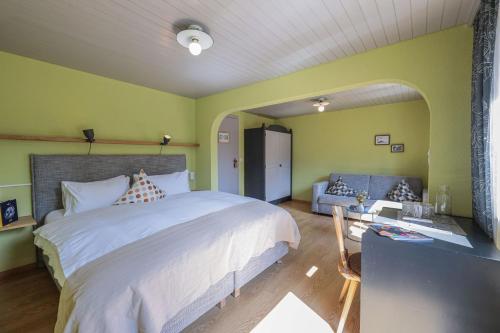 a bedroom with a large bed and a couch at Hotel Seehof-Arosa in Arosa