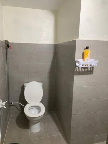a bathroom with a white toilet in a stall at Zahra Homestay in Rantau Panjang