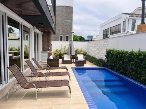 a patio with chairs and a swimming pool at Casa Jurere in Florianópolis