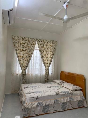 a bedroom with a bed and a window at Zahra Homestay in Rantau Panjang