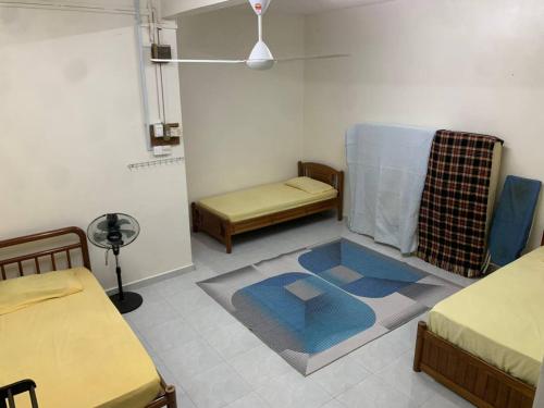 a small room with two beds and a rug at Zahra Homestay in Rantau Panjang