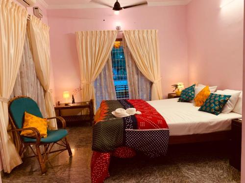 Un dormitorio con una cama con una manta de colores. en Surendram Villa en Varkala