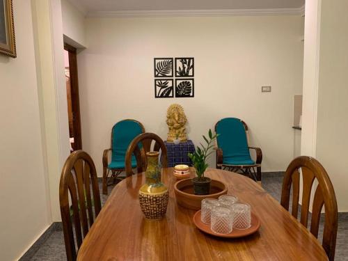 comedor con mesa de madera y sillas en Surendram Villa, en Varkala