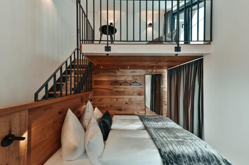 een slaapkamer met een bed met een houten hoofdeinde bij ZSAM Chalets mit Sauna und Hottub in Garmisch-Partenkirchen
