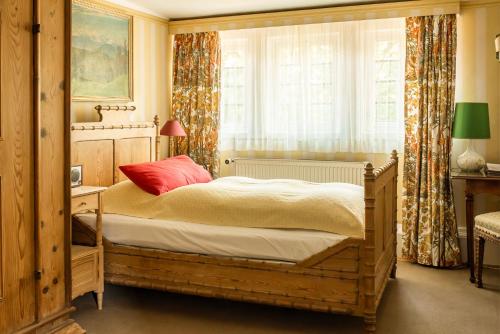 1 dormitorio con cama de madera y ventana en Hotel Schloss Büdingen, en Büdingen