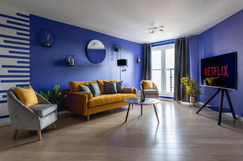 - un salon avec un canapé jaune et des murs bleus dans l'établissement Jade Apartments Basildon, à Basildon