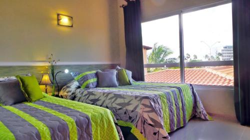 a bedroom with two beds and a large window at Family-Flexication-Friendly Villa, few steps from Eagle Beach in Palm-Eagle Beach