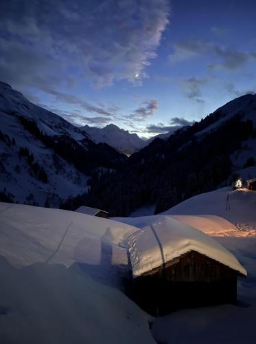 a snow covered hut on top of a snow covered mountain at Älpler Stuba Appartements am Lärchenhof in Warth am Arlberg