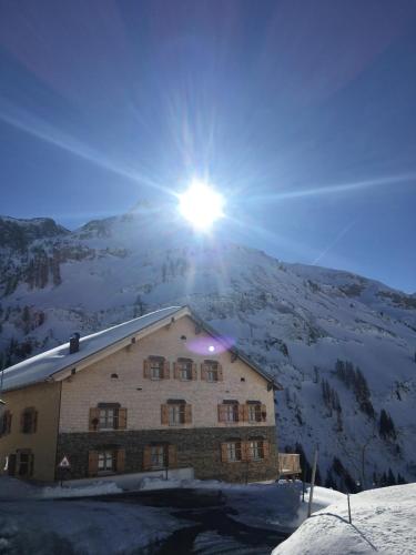 a building with the sun on top of a mountain at Älpler Stuba Appartements am Lärchenhof in Warth am Arlberg