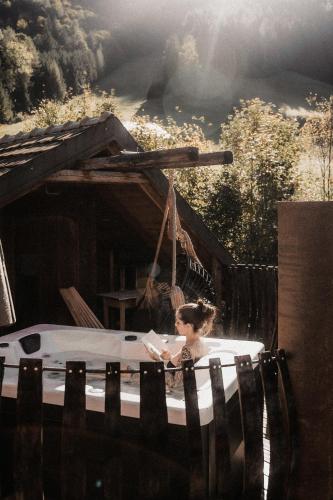 a woman sitting in a hot tub in a house at Troadkasten - Nationalpark Kalkalpen in Ramsau