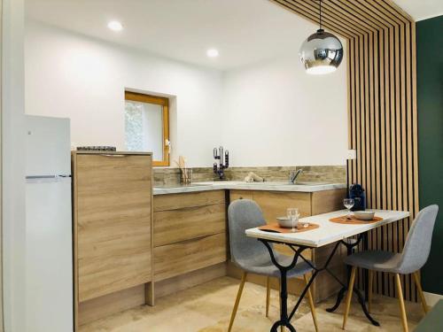 a kitchen with a table and chairs and a sink at Le studio Adhémar - parking sur place in Montboucher-sur-Jabron