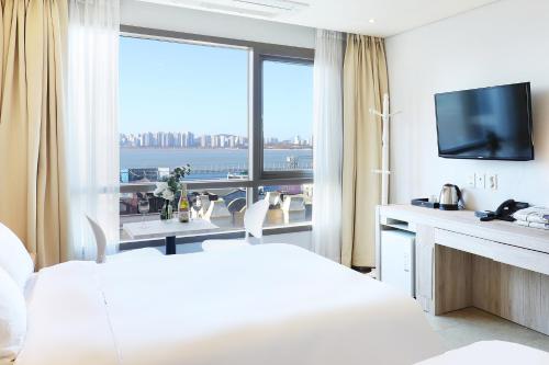 a hotel room with a bed and a large window at Hotel The Sea Star in Incheon