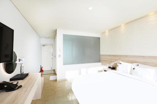 a living room with a flat screen tv and a couch at Hotel The Sea Star in Incheon