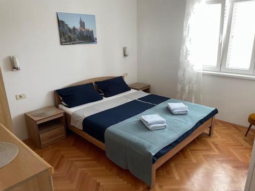een slaapkamer met een bed met twee handdoeken erop bij Superior Rooms Sea Side View in Rab