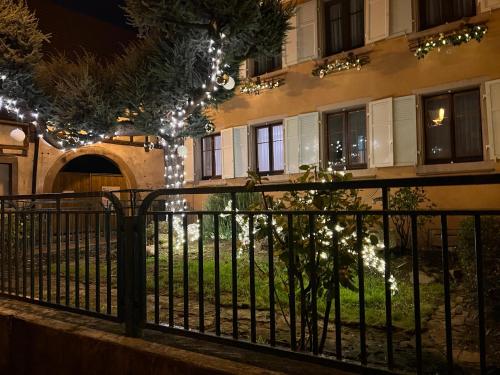 une clôture devant un bâtiment aux lumières de Noël dans l'établissement Chambre Pastis, à Eguisheim