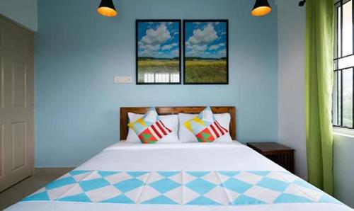 1 dormitorio con 1 cama con paredes y ventanas azules en FabHotel Majestic Heights, en Ernakulam