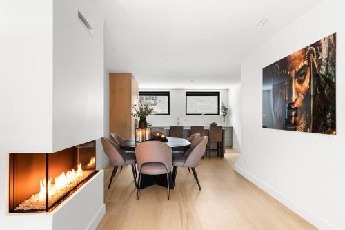 a dining room with a fireplace and a table and chairs at Fully serviced luxury townhouse near the Vigelandspark in Oslo