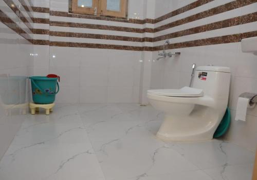 ein weißes Bad mit WC im Zimmer in der Unterkunft Mountain Bliss Cottages by StayApart in Shoja