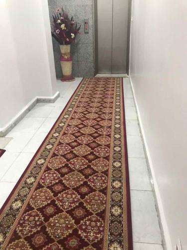 a corridor with a rug on the floor in a hallway at HOTEL IKRAM in Fort de lʼEau