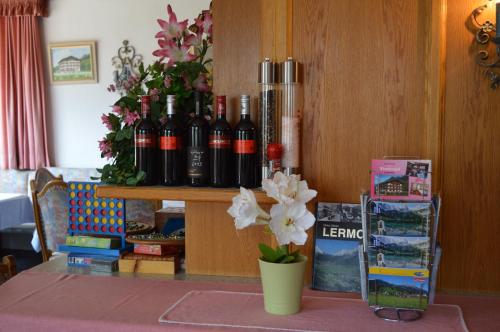 a table with bottles of wine and flowers on it at Tirolerhof in Lermoos