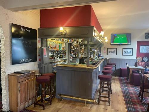 um bar num restaurante com bancos de bar em The Board Inn em Hawes