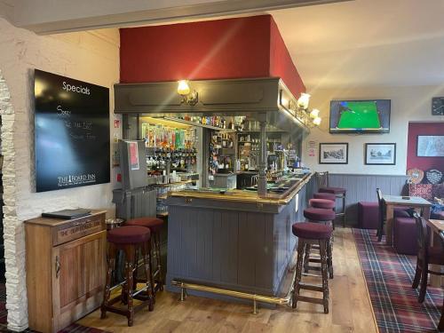 a bar in a restaurant with bar stools at The Board Inn in Hawes