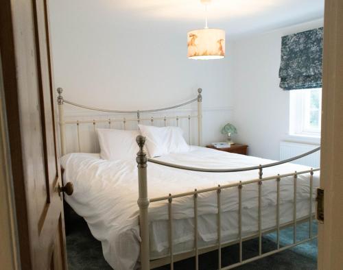 a bedroom with a bed with white bedding at Bridge House in Chichester