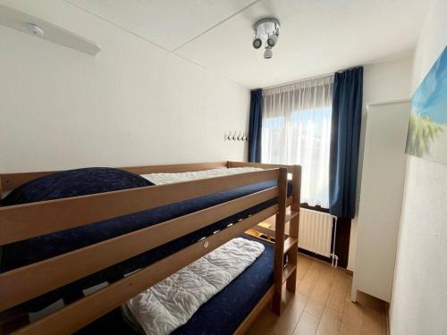 a bedroom with two bunk beds and a window at Schorrebloem 31 in Nieuwvliet