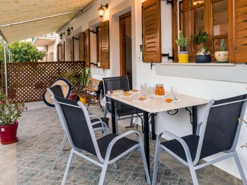 stół i krzesła na patio w obiekcie Catherine Blue Suites - 4 minutes off the Beach w mieście Poros