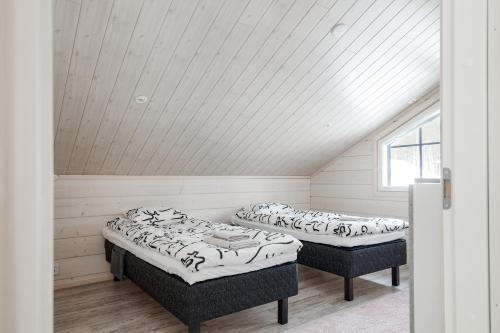 2 Betten in einem Zimmer mit Dachgeschoss in der Unterkunft Lymyilevi in Levi