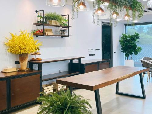 a dining room with two tables and potted plants at Sand Dance Hotel in Prachuap Khiri Khan