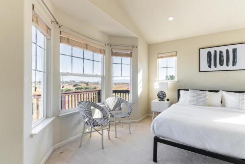 a bedroom with a bed and two chairs and windows at Newark 4br w backyard patio ac garage SFO-1586 in Newark