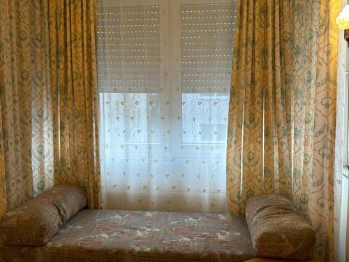 a couch in front of a window with curtains at WestEnd#201 in Frankfurt