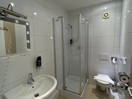 een badkamer met een douche, een wastafel en een toilet bij WestEnd#201 in Frankfurt am Main