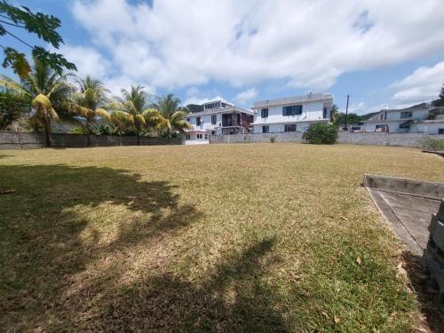 a large yard with palm trees and houses at Cocotiers in Beau Champ