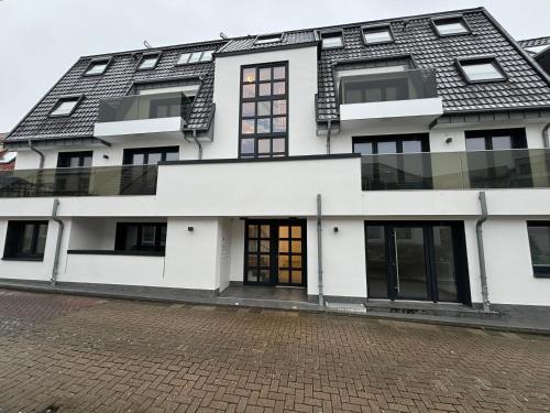 a white building with a black roof at Haus Noena - Wohnung 7 Inselschatz in Norderney