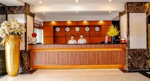 two people sitting at a bar in a restaurant at Hoa Nam Hotel 