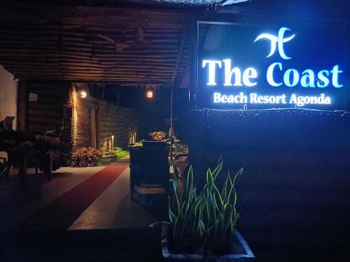 a sign for the coast beach resortania on a wall at The Coast Beach Resort in Agonda