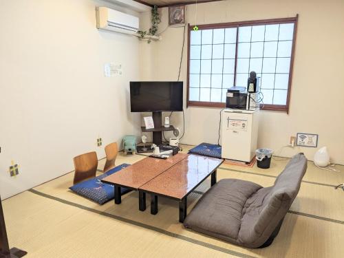 un soggiorno con tavolo, divano e TV di OYO Ryokan Hamanako no Yado Kosai - Vacation STAY 38825v a Kosai