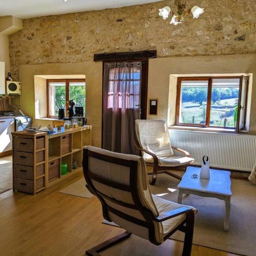 un salon avec deux chaises et une table dans l'établissement La Gentilhommière SPA et piscine privée, à Bourniquel