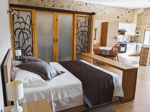 une chambre avec un grand lit et une cuisine dans l'établissement La Gentilhommière SPA et piscine privée, à Bourniquel