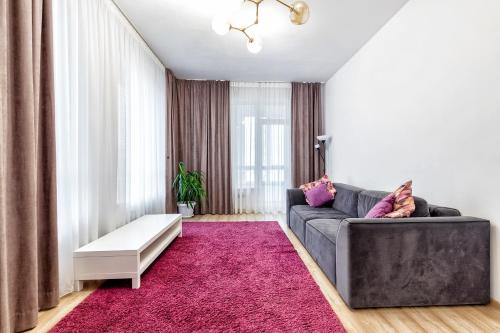 a living room with a couch and a pink rug at Комфортная квартира на ЭКСПО/ Comfortable flat on EXPO in Taldykolʼ