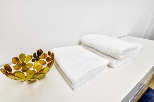 a white counter with towels and a bowl of flowers at Комфортная квартира на ЭКСПО/ Comfortable flat on EXPO in Taldykolʼ
