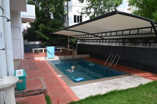 una piscina con dosel en el patio trasero en Royal Experiences Pearl House 6 Bed Room Villa with Private Pool, Panayur, en Chennai