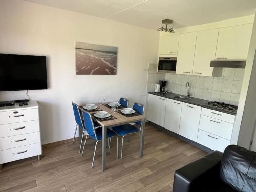 a kitchen with a table and chairs in a room at Schorrebloem 34* in Nieuwvliet
