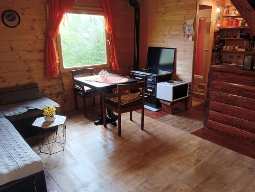 uma sala de estar com uma mesa e uma televisão em Mountine cottage Hajdi em Andrijevica