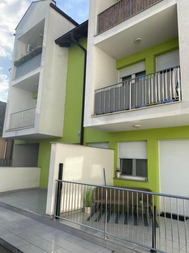 un edificio de apartamentos con zonas verdes y blancas en Studio apartman Aurora en Ðakovo